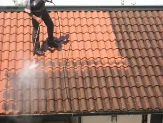 Nettoyage de toiture au jet haute pression par un professionnel.